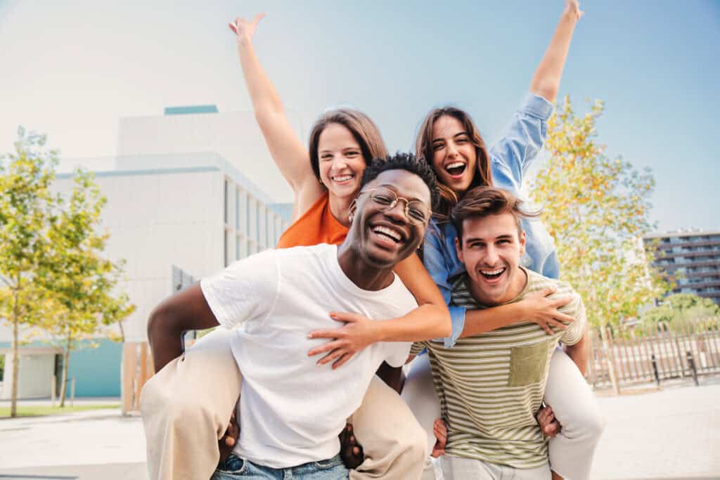 Group of young adults enjoying outdoors, representing community strength.