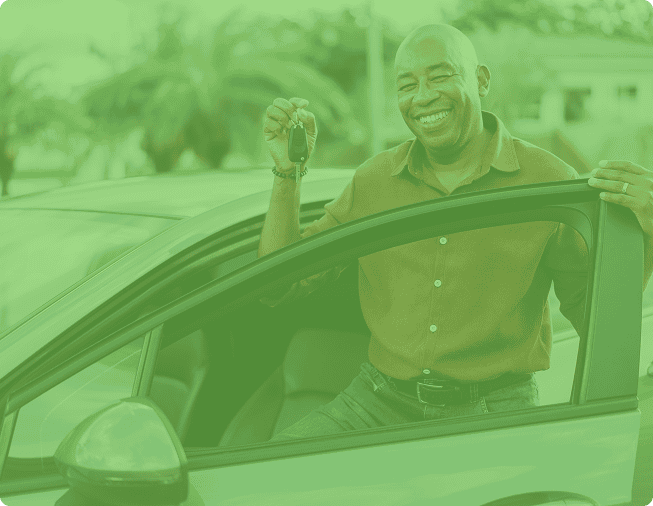 Happy man holding car keys outside, smiling, at St. Tammany FCU.